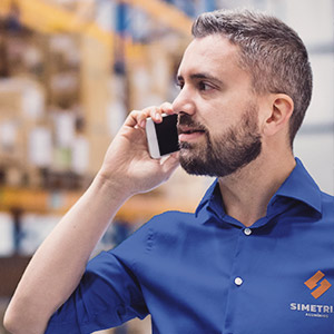 Atendente falando no telefone com uniforme da Simetria Alumínios